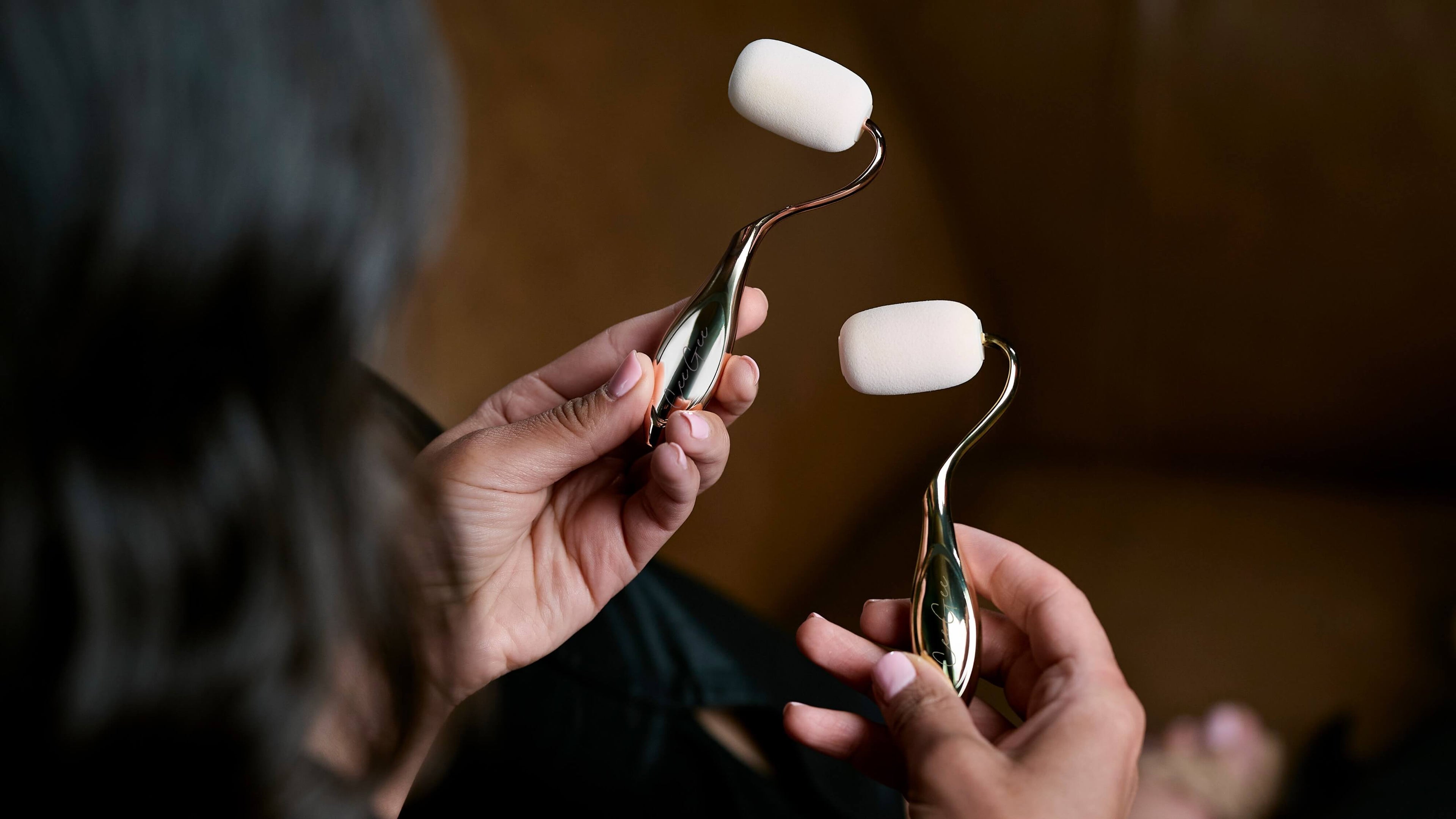 Two rolli sponges with white stones held by a person against a blurred background