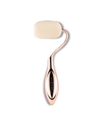 Rose gold rolli sponge with beige roller head on a black background